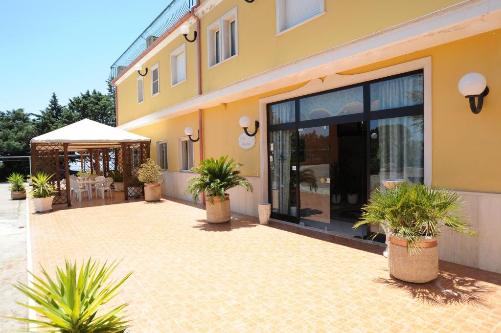 un bâtiment avec des plantes en pot devant lui dans l'établissement Hotel Garden, à San Giovanni Rotondo