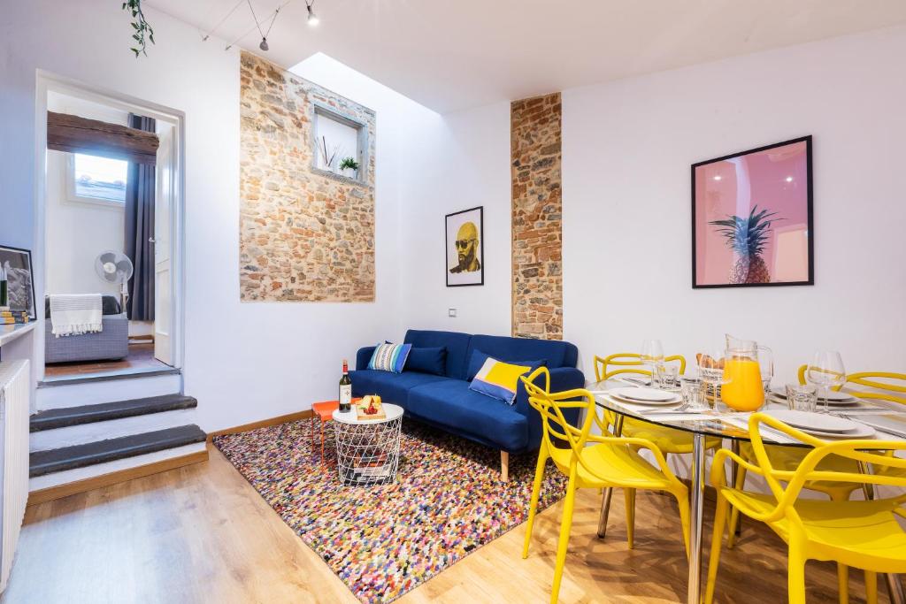 ein Wohnzimmer mit einem blauen Sofa, einem Tisch und Stühlen in der Unterkunft Historic center renovated apartment- Amazing location- AC and Elevator in Florenz