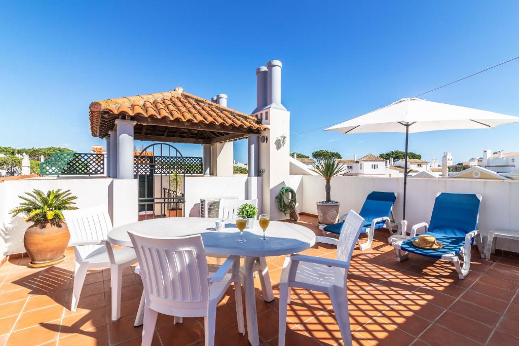 a patio with a table and chairs and an umbrella at The Old Village, Prestige and Solar by Village 4U in Vilamoura