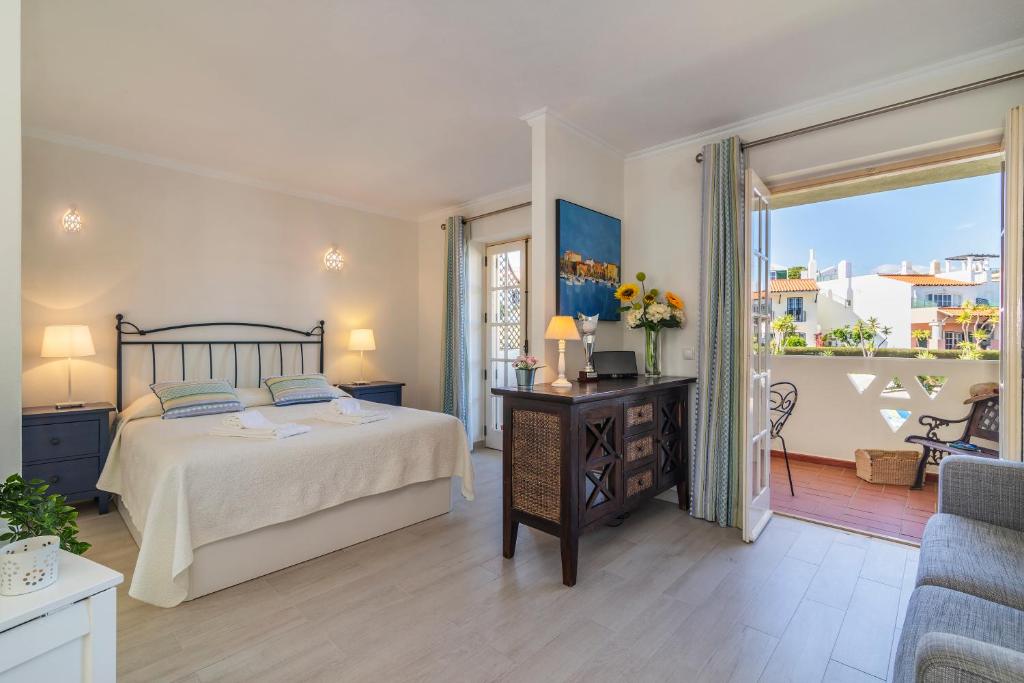 a bedroom with a bed and a balcony at The Old Village, Prestige and Solar by Village 4U in Vilamoura