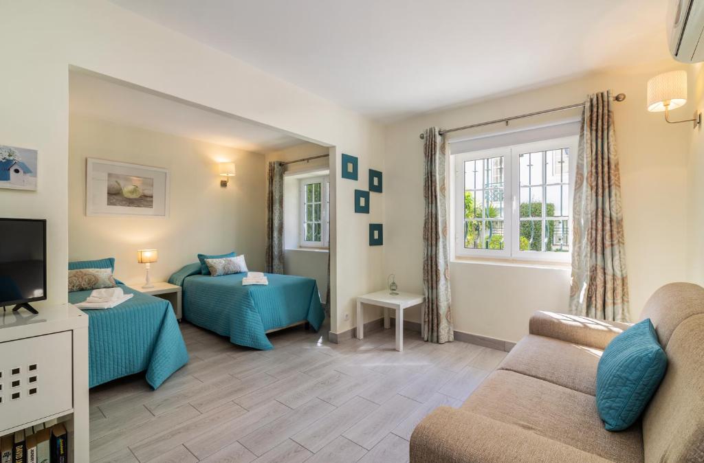 a living room with a couch and a bed and a tv at The Old Village, Prestige and Solar by Village 4U in Vilamoura