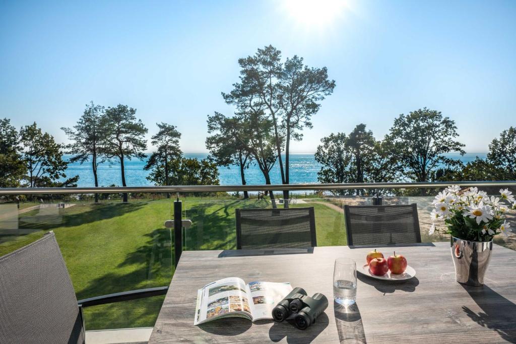 ein Tisch auf einem Balkon mit Blick auf das Meer in der Unterkunft Appartement "Karat" mit Penthouseflair - Oase am Haff in Garz