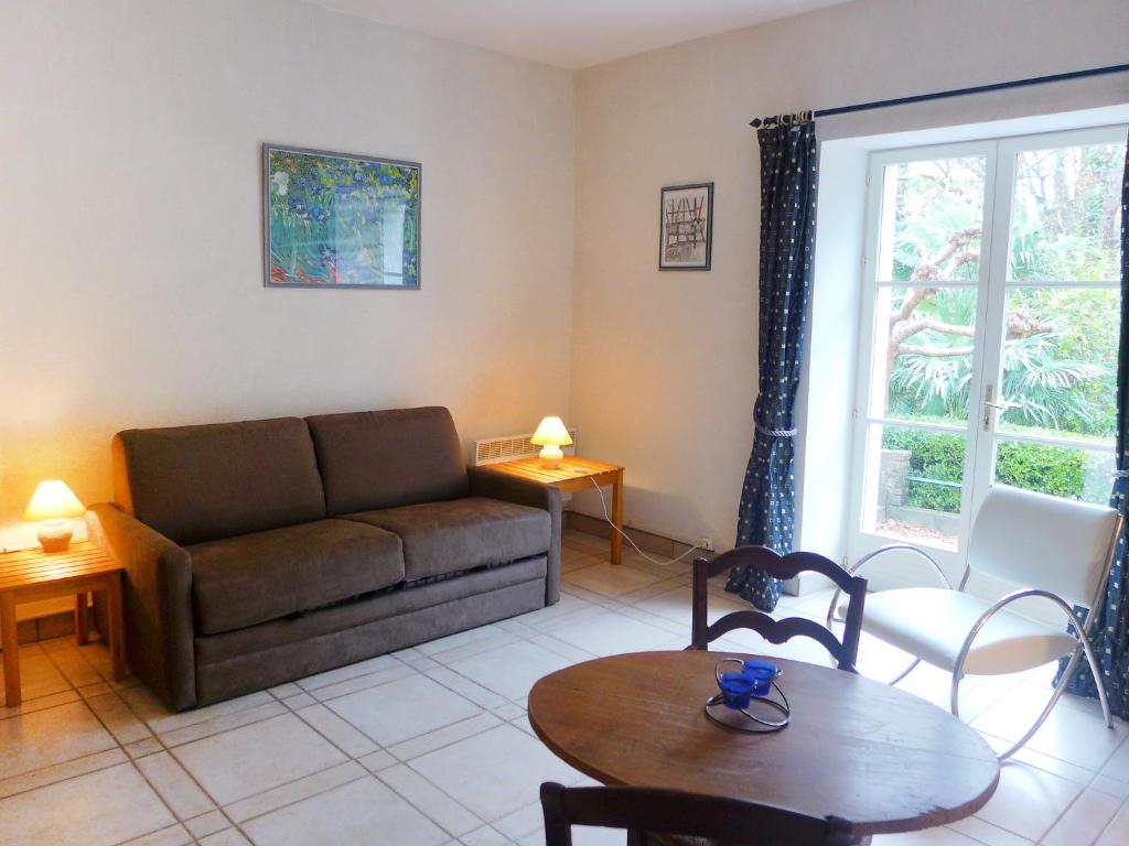 a living room with a couch and a table at Holiday Home Le chant des milans by Interhome in Ondres