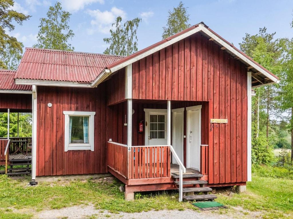 a red tiny house with a porch at Holiday Home Naurulokki 4 by Interhome in Strandby