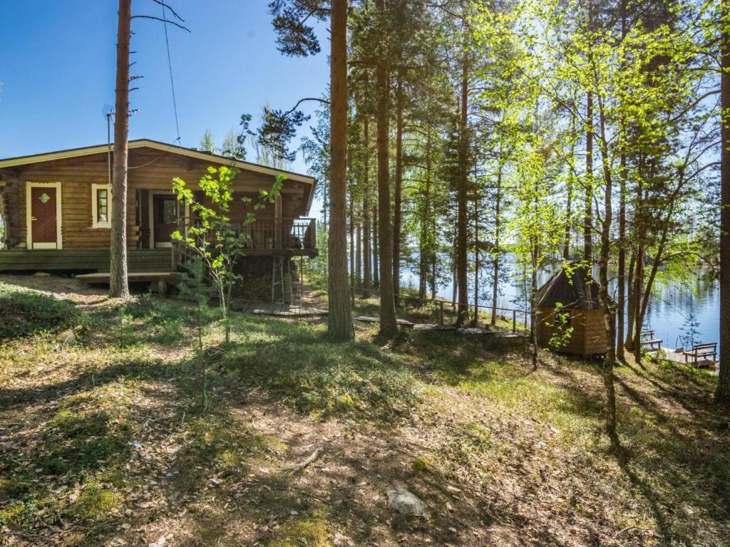 a cabin in the woods next to a lake at Holiday Home Patu by Interhome in Pihlajaniemi