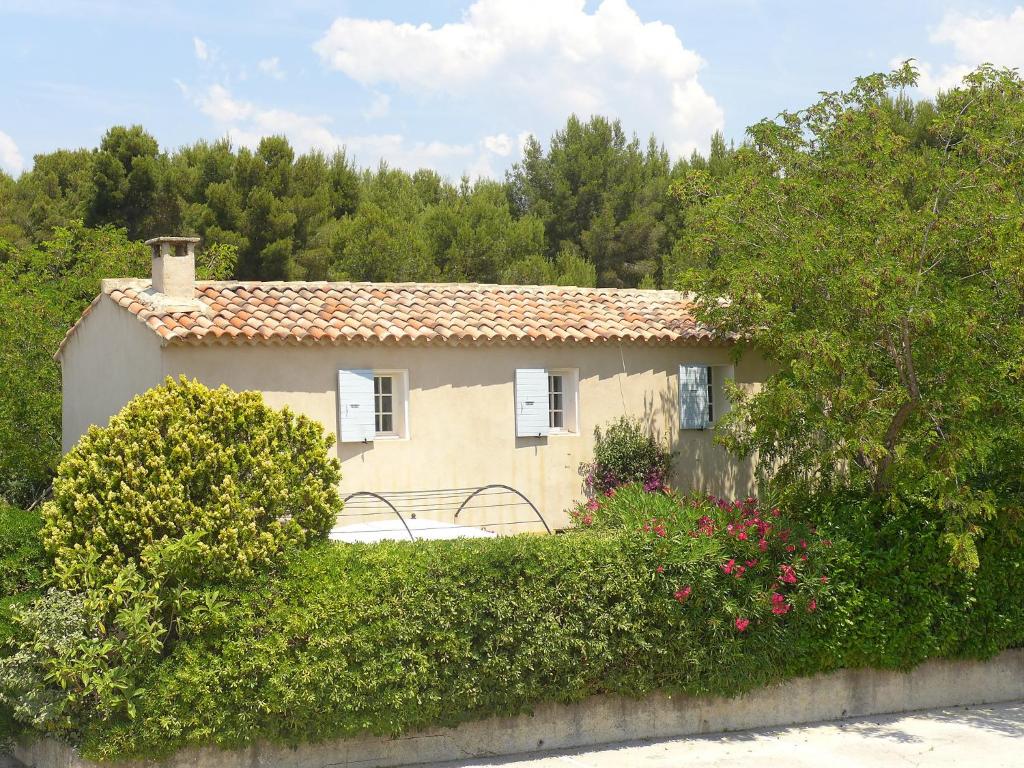 a small house with bushes and flowers in front of it at Holiday Home Le Mazet by Interhome in Les Lecques