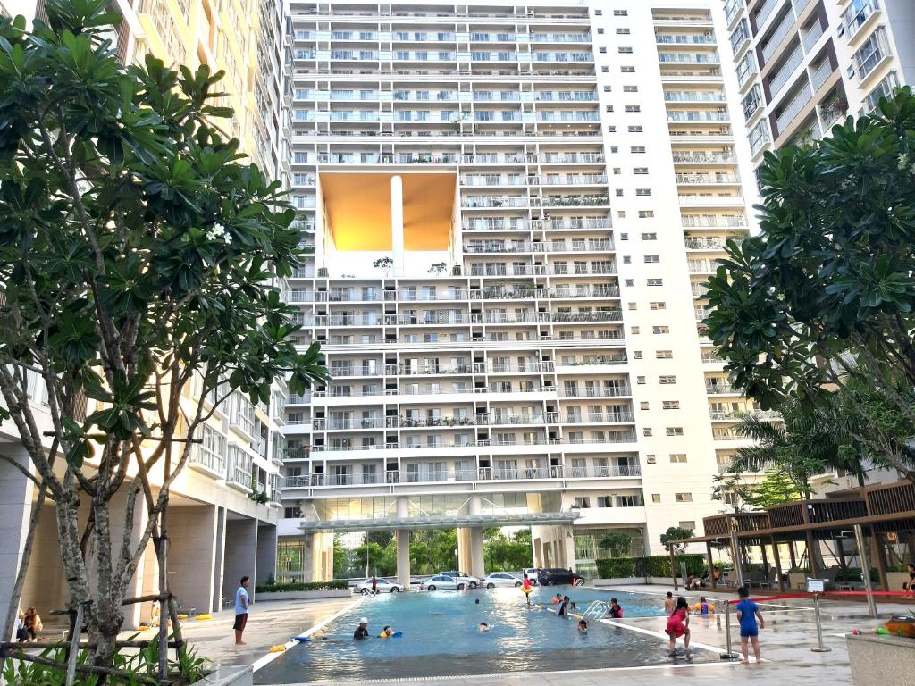 a large building with a swimming pool in front of it at Scenic Valley Suite in Ho Chi Minh City