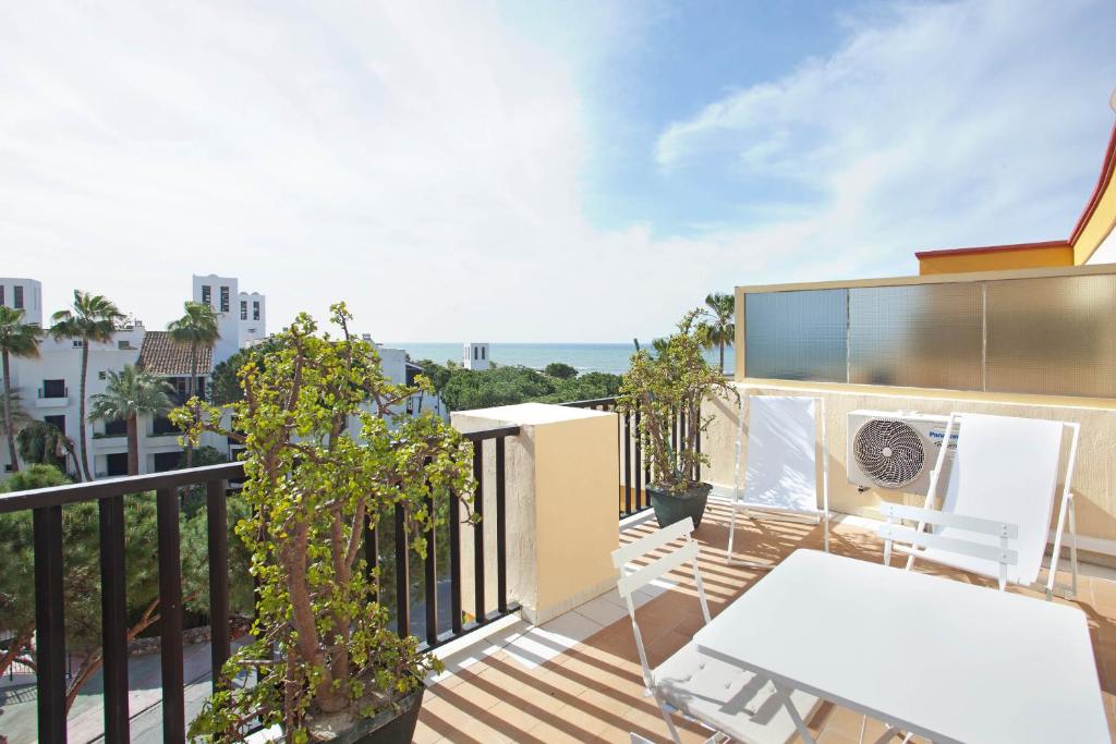 - Balcón con mesa y sillas en un edificio en Romana Playa Elviria, en Marbella