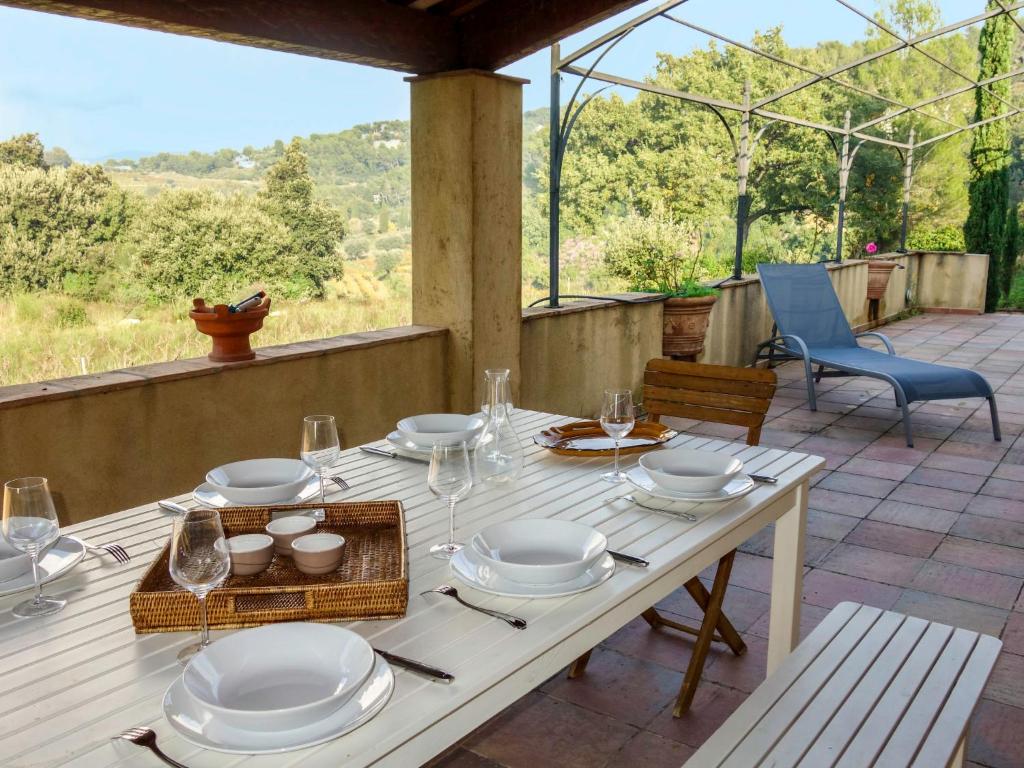 a table with plates and wine glasses on a patio at Holiday Home Le Nid by Interhome in Le Plan