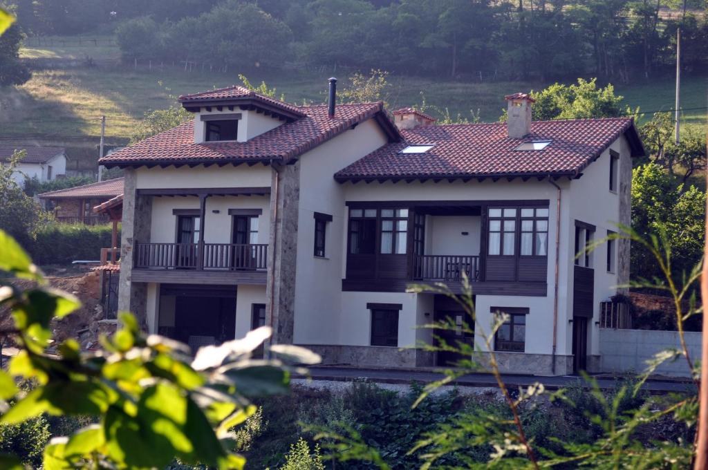 ein weißes Haus mit rotem Dach in der Unterkunft La Casona de Palu in Pola de Laviana