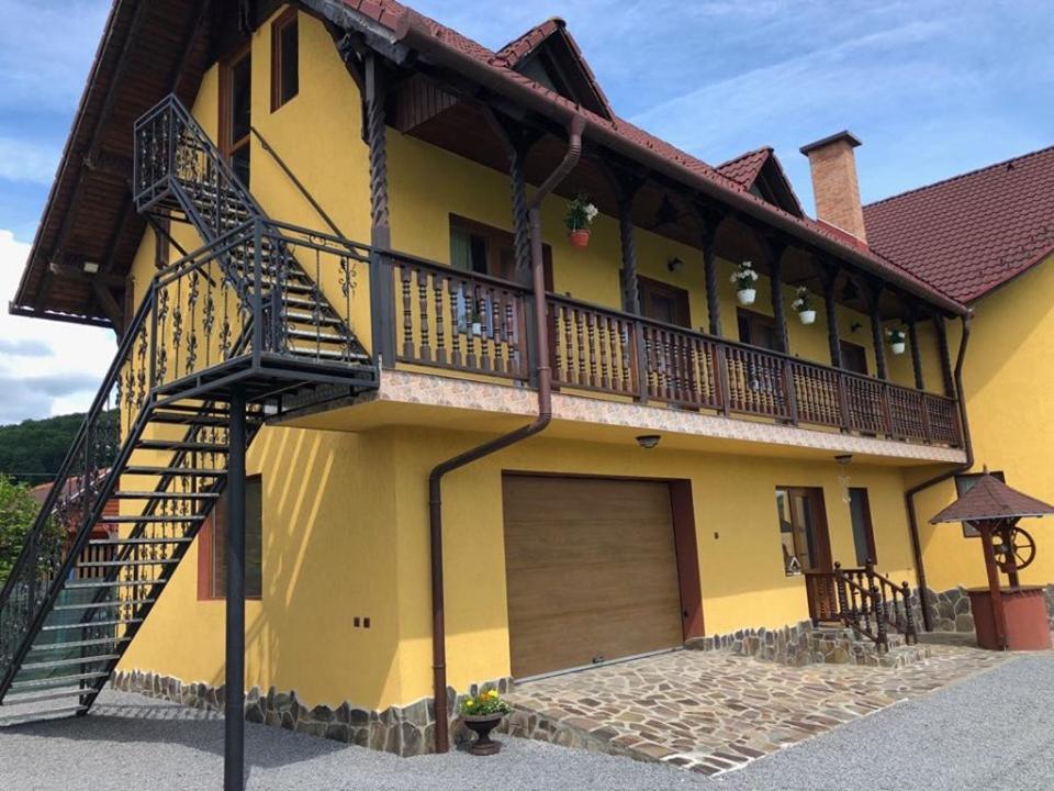 a yellow house with a staircase on the side of it at Casa Bambi in Sovata