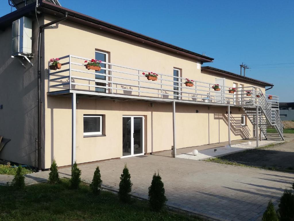 a building with a balcony and stairs on it at Ararauna in Kamienica