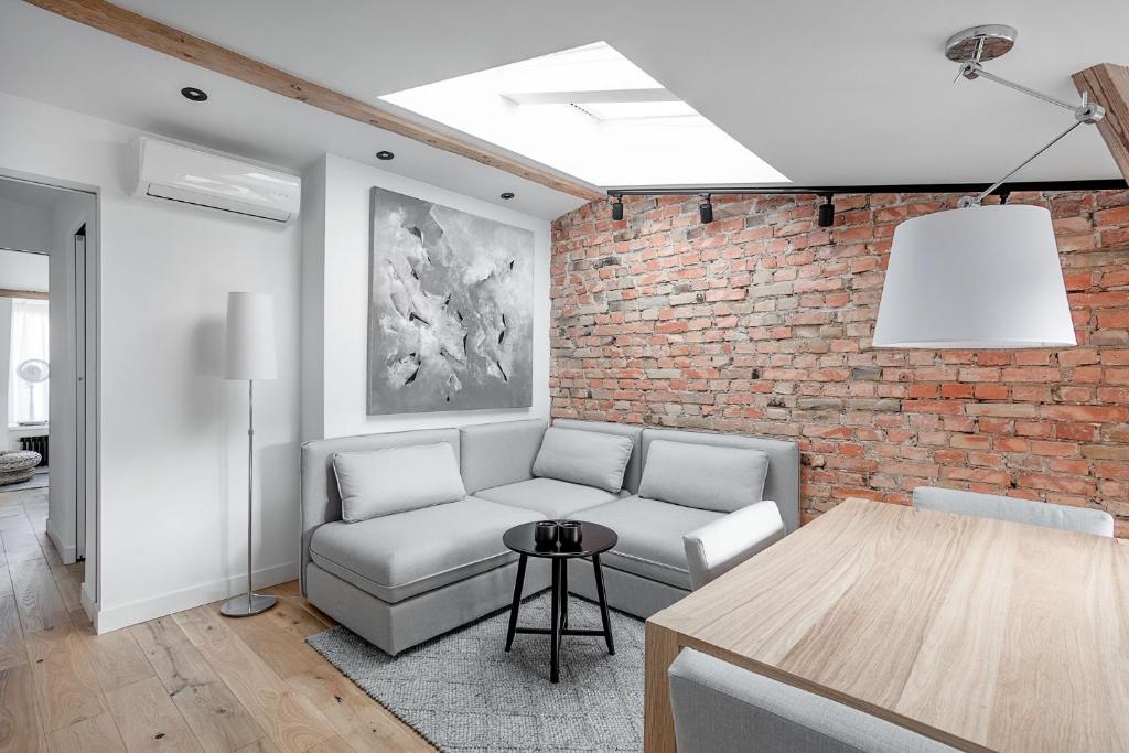 a living room with a couch and a brick wall at VIU The Roof Apartment in Sopot