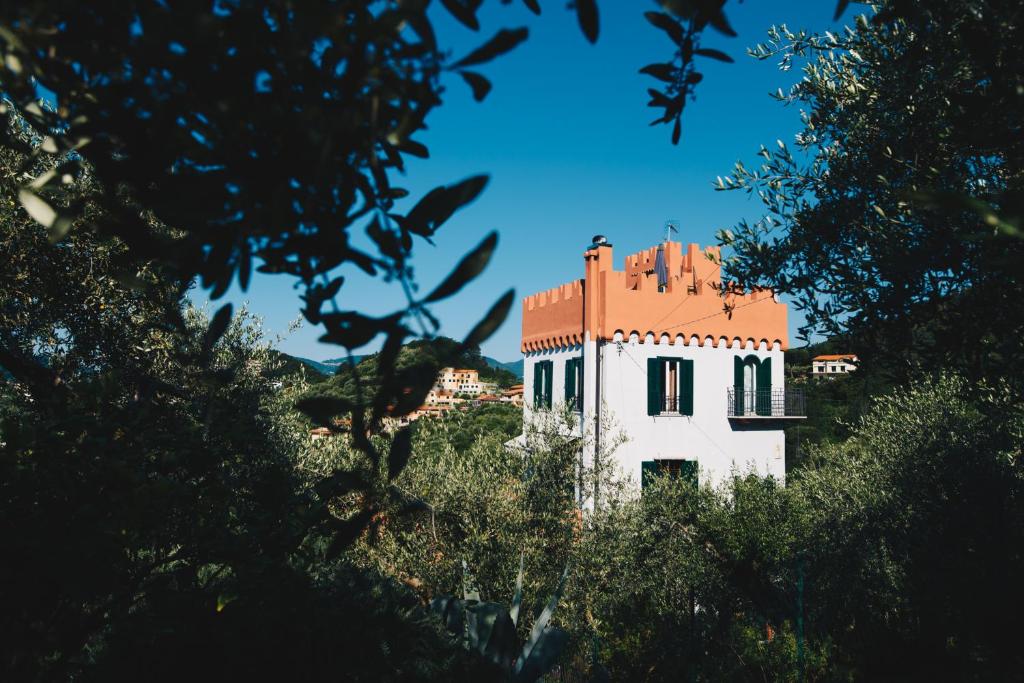 a white building with a red roof with trees at La Torretta in Lerici