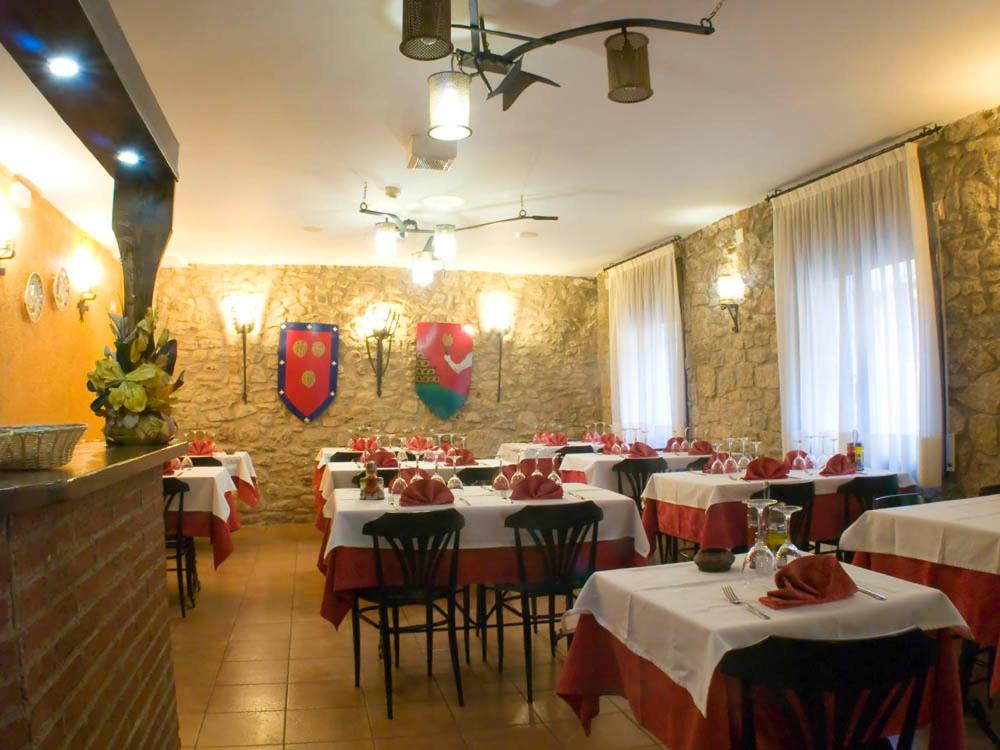 un restaurante con mesas y sillas rojas y blancas en Fonda Bohemia Riuot, en Montblanc