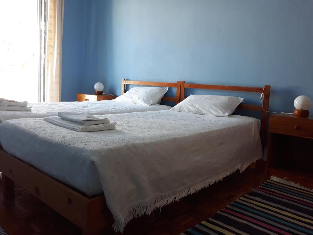 a blue bedroom with a bed with two towels on it at Pensão Algarve in Loulé