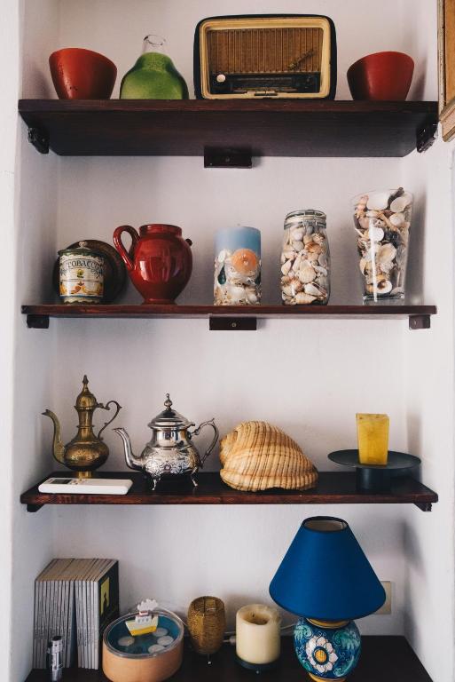 a shelf filled with pots and pans and a blue lamp at La Torretta in Lerici