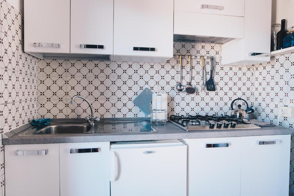 a kitchen with white cabinets and a sink at La Torretta in Lerici