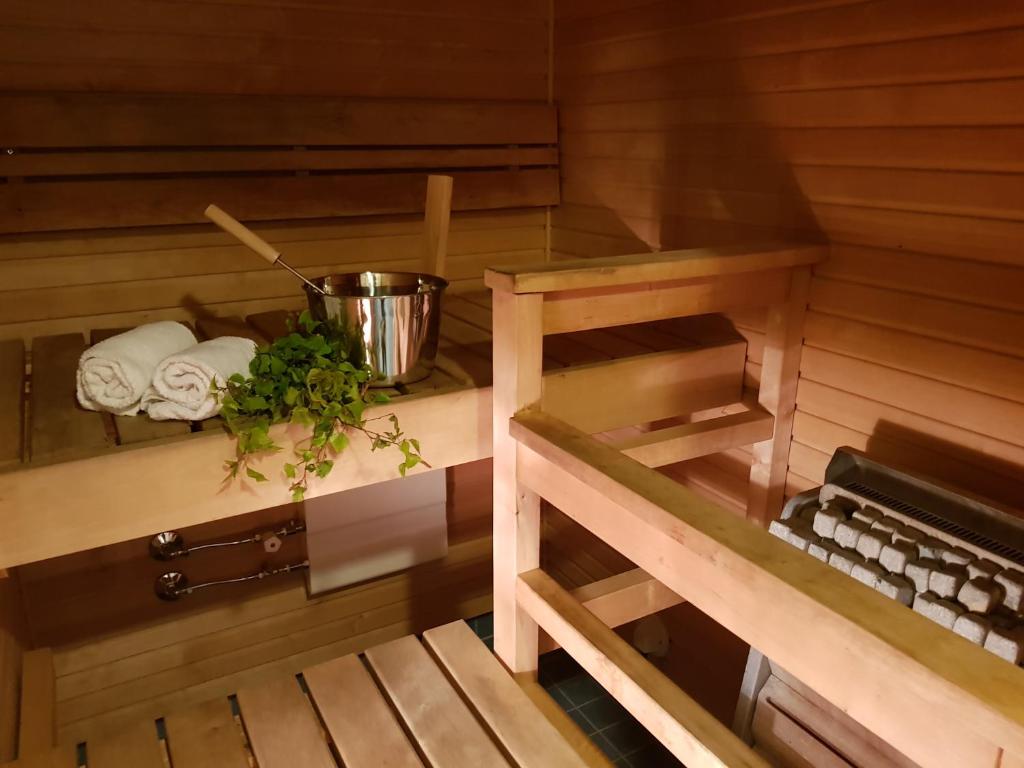 a sauna with a bowl and towels on a shelf at 2ndhomes Deluxe Kamppi Center Apartment with Sauna in Helsinki
