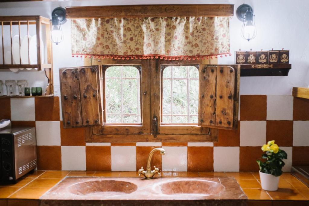 kuchnia ze zlewem i oknem w obiekcie Cortijo Rural Majolero w mieście Castillo de Locubín