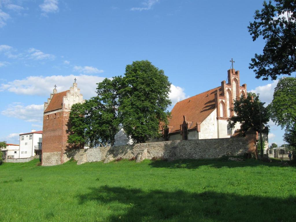uma igreja numa colina ao lado de um campo verde em Pokoje nad jeziorem Mazury em Dabrówno