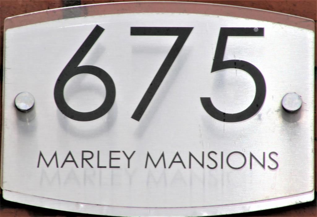 una señal blanca con el número en Marley Mansion Apartments - Borough, en Birkenhead