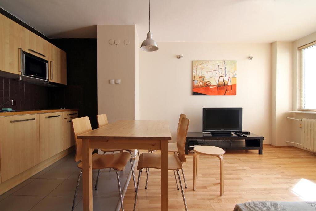 a kitchen and dining room with a table and chairs at Apartament Skwer Gdynia in Gdynia