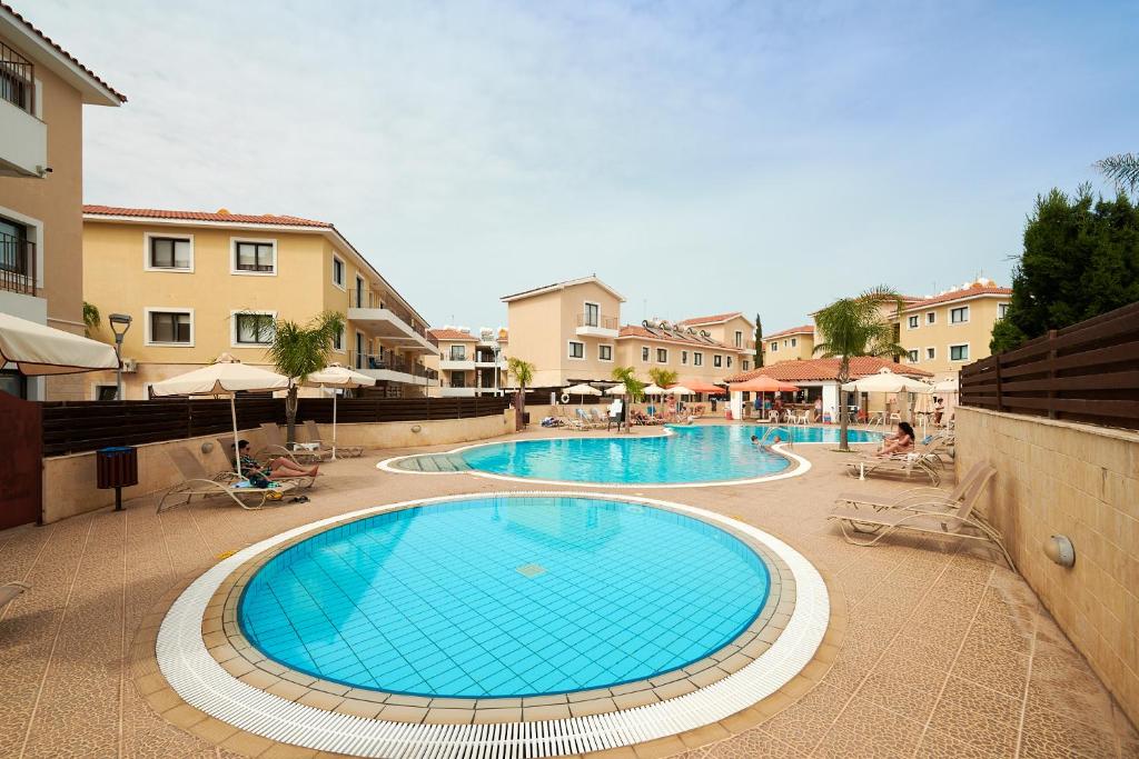 a large swimming pool with chairs and umbrellas at Kyklades Angie Resort in Protaras