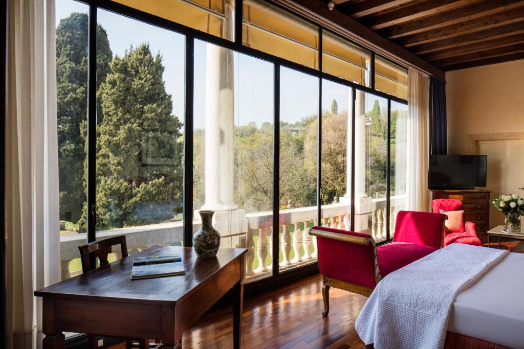 una camera con un letto e una grande finestra di Villa Michelangelo Vicenza – Starhotels Collezione ad Arcugnano