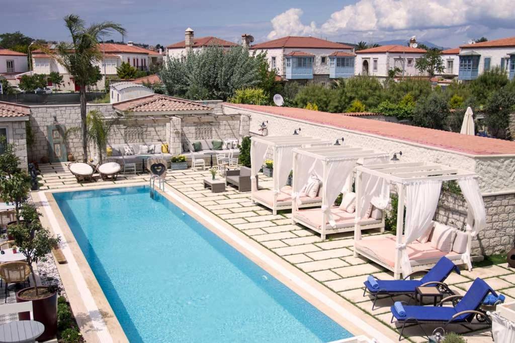 a swimming pool with chaise lounge chairs and a resort at Casa Luna Hotel - Adult Only in Alaçatı