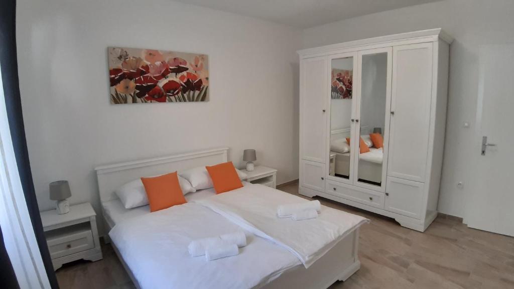 - une chambre avec un lit blanc et des oreillers orange dans l'établissement Relax, à Starigrad-Paklenica
