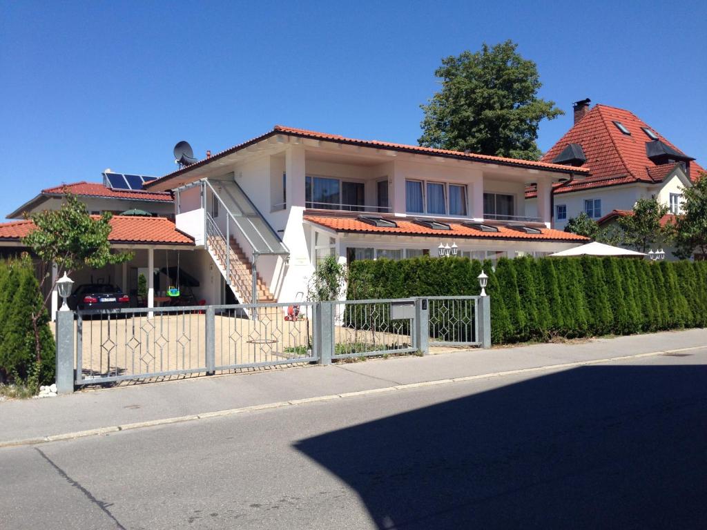 een wit huis met een hek voor een straat bij Haus San Marco in Füssen