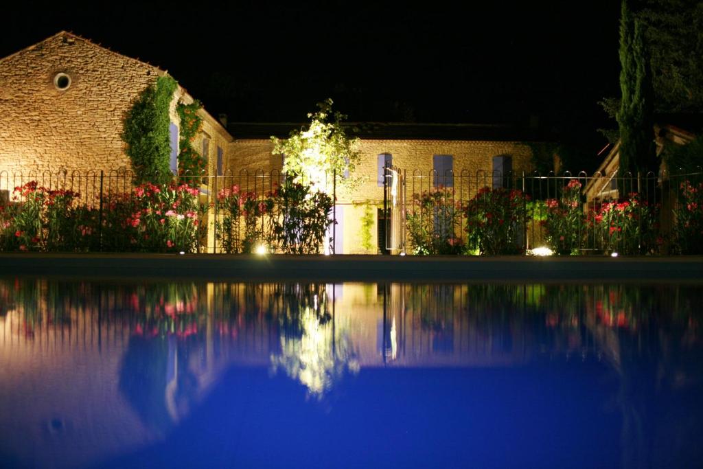 une maison la nuit avec une réflexion dans l'eau dans l'établissement La Pastorale, à Lagnes