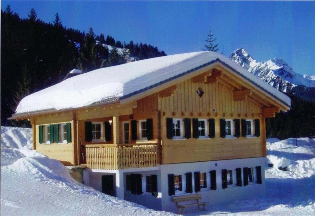 a log cabin with snow on the roof at Haus zur Kapelle in Sankt Gallenkirch