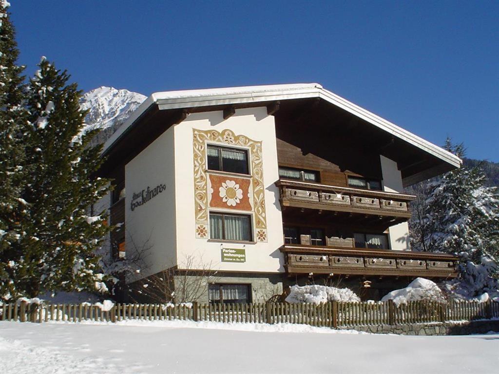 ein großes Gebäude mit einem Zaun im Schnee in der Unterkunft Haus Lifinar - Carmen Juen in Sankt Gallenkirch
