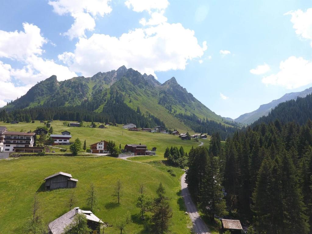 un campo verde con una montagna sullo sfondo di Haus Ritzenspitze a Gargellen
