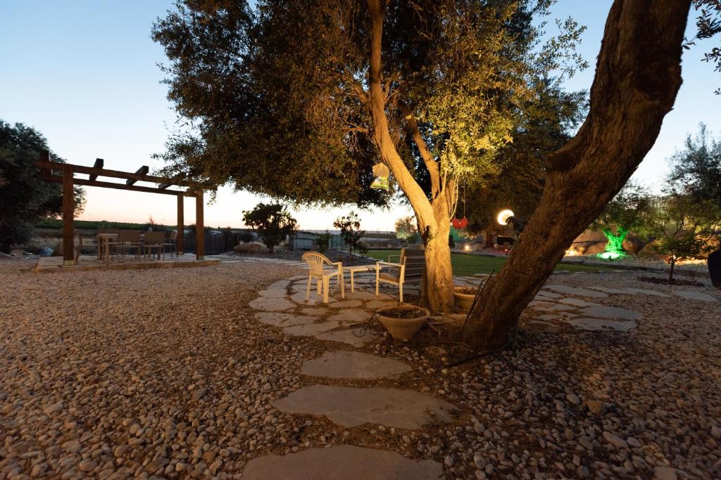 a table and chair under a tree in a park at Hemdat Nefesh Eitan in Eitan