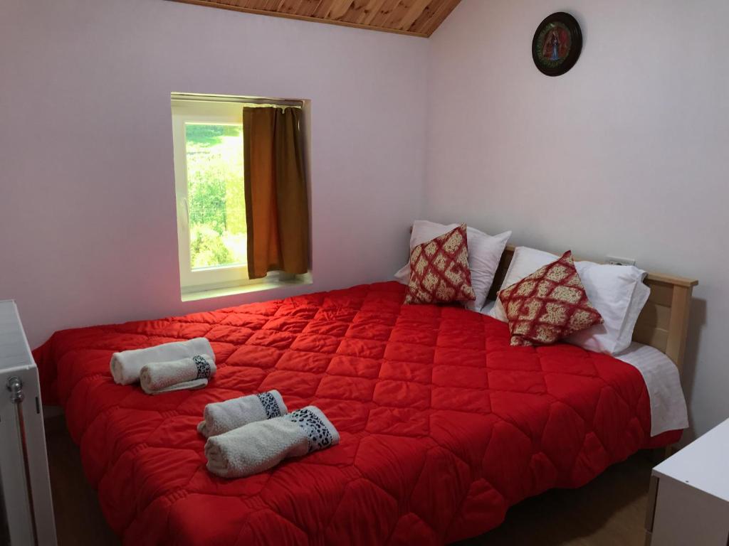 a bedroom with a large red bed with a window at Guesthouse Makry in Pukë
