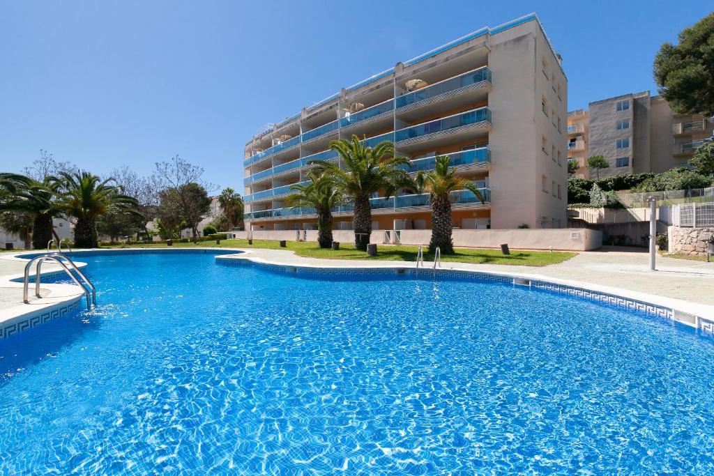 a large swimming pool in front of a building at UHC Bellavista Apartments in Salou