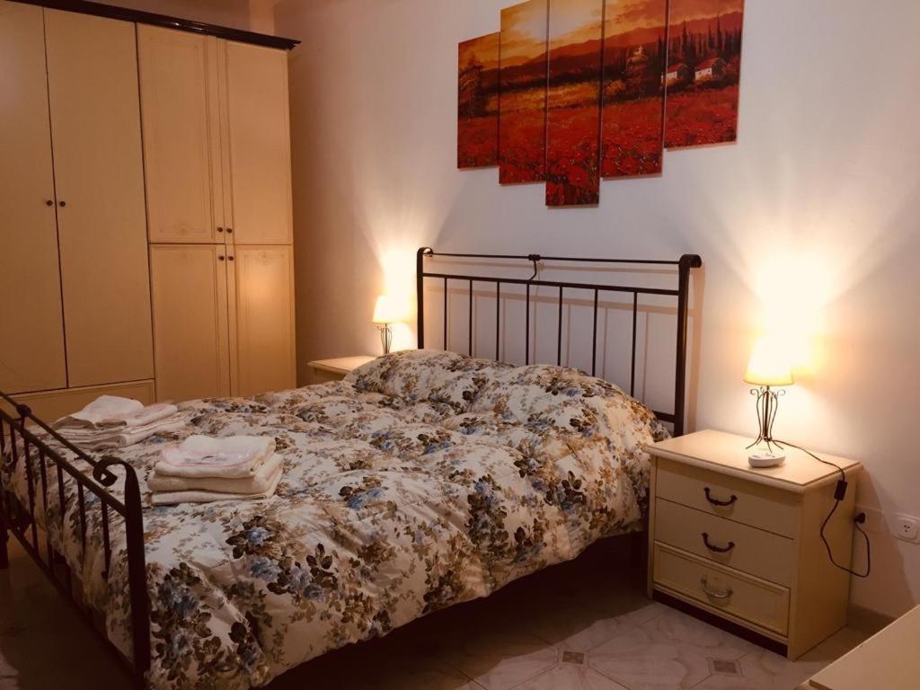 a bedroom with a bed and two night stands with lamps at Casa Petralia in Petralia Sottana