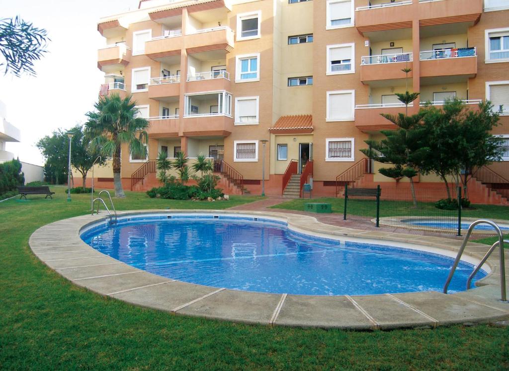una piscina frente a un edificio en Apartamentos Cibeles, en Roquetas de Mar