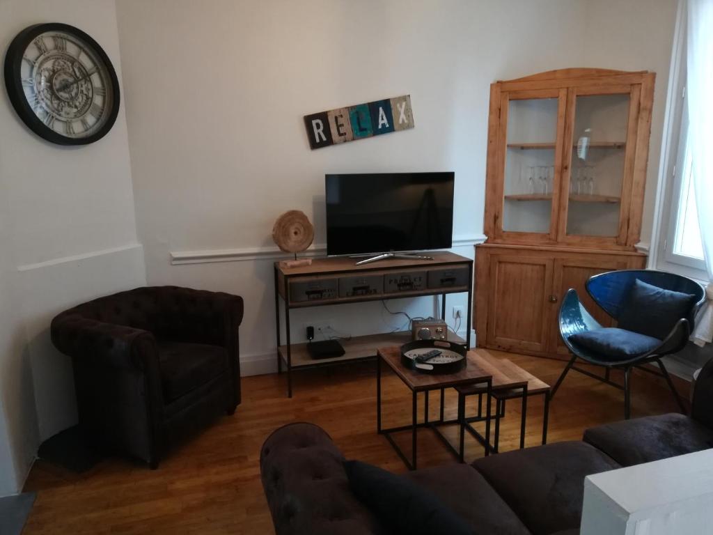 a living room with a couch and a tv at L Alchimie in Fécamp