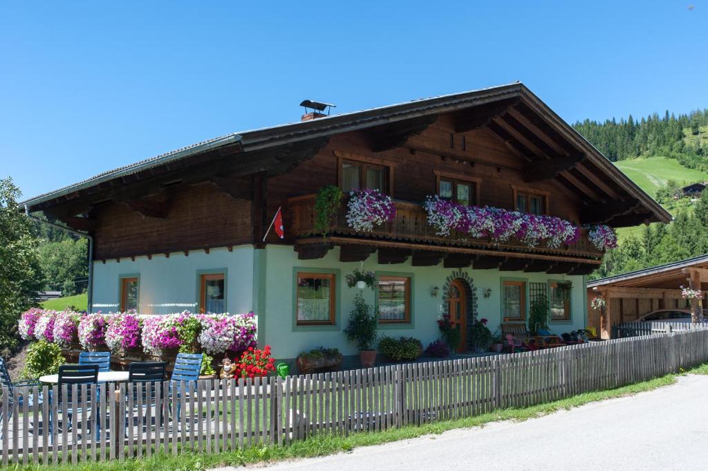 a house with flowers in front of it at Kleinwidmoos-Apartment in Wagrain