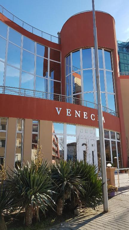 a building with a sign on the side of it at Hotel Venecia in Primorsko