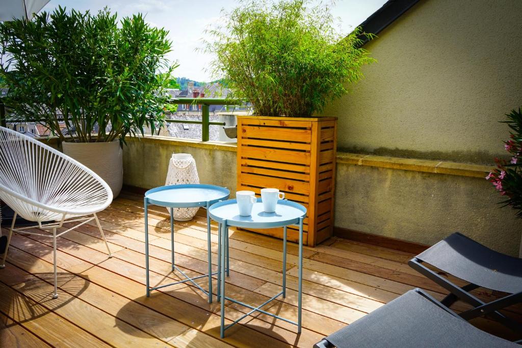 d'un balcon avec deux tables et des chaises ainsi qu'une commode. dans l'établissement L'Eden Urbain - 2 Chambres, à Brive-la-Gaillarde
