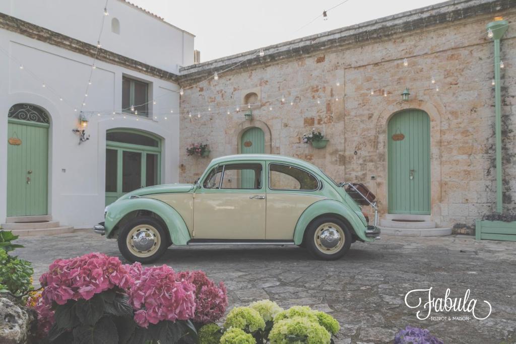a green and white car parked in front of a building at Masseria Fabula Bistrot & Maison in Monopoli