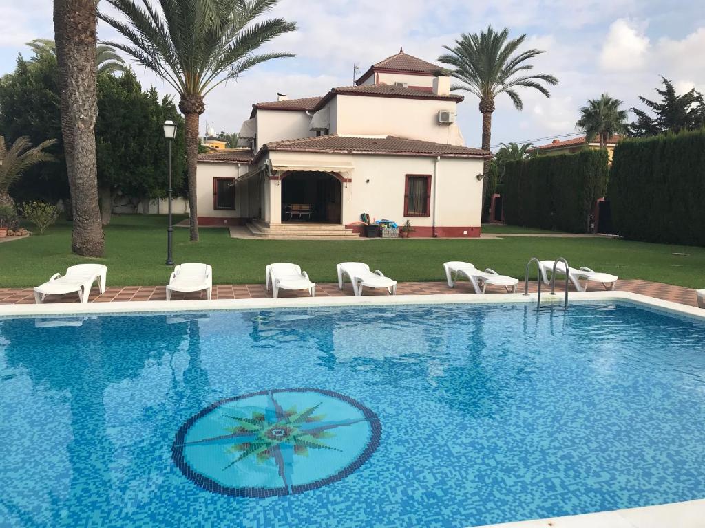 a swimming pool with a house in the background at Hacienda de Lula in El Campello
