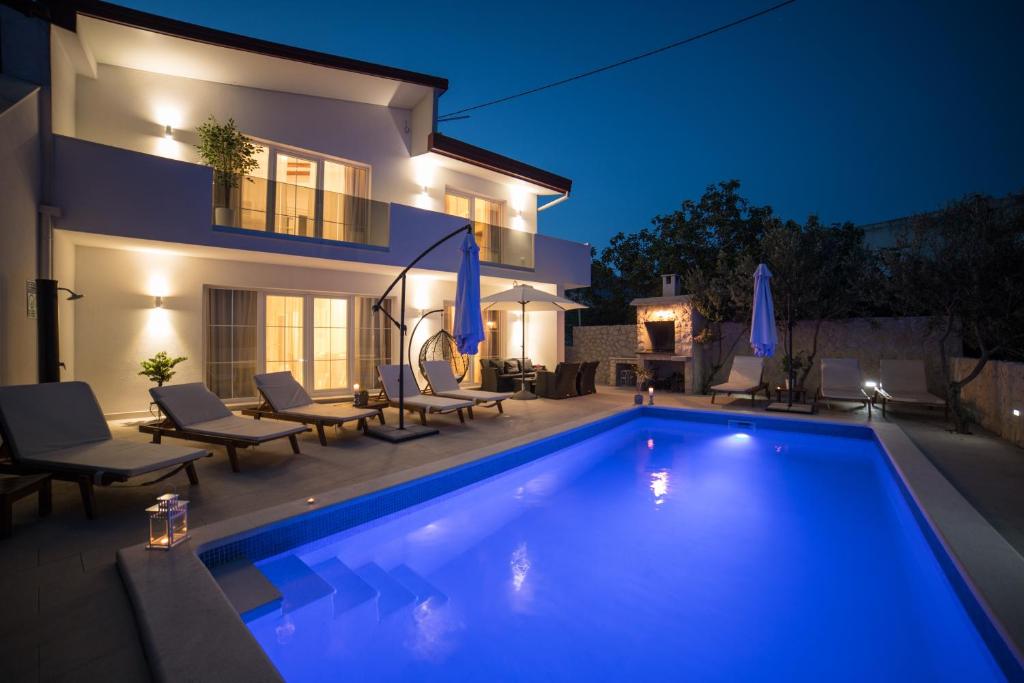 a swimming pool in front of a house at night at Villa Sunset in Kastel Novi