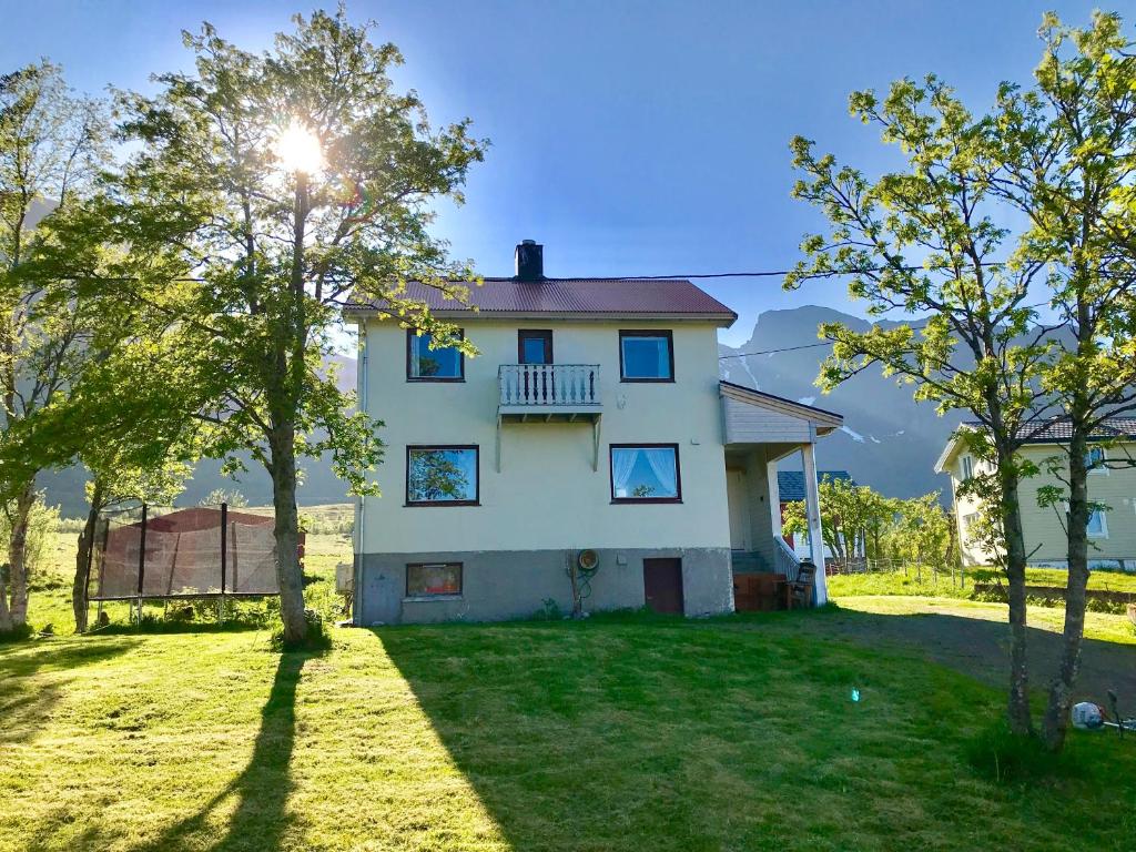 uma casa branca com um quintal com árvores em Lofoten Bay View em Bøstad