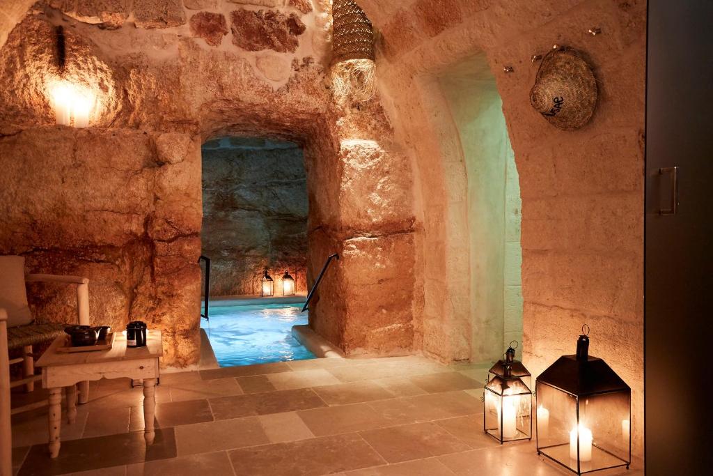 a room with a pool in a cave with lights at Musae Relais & SPA in Polignano a Mare